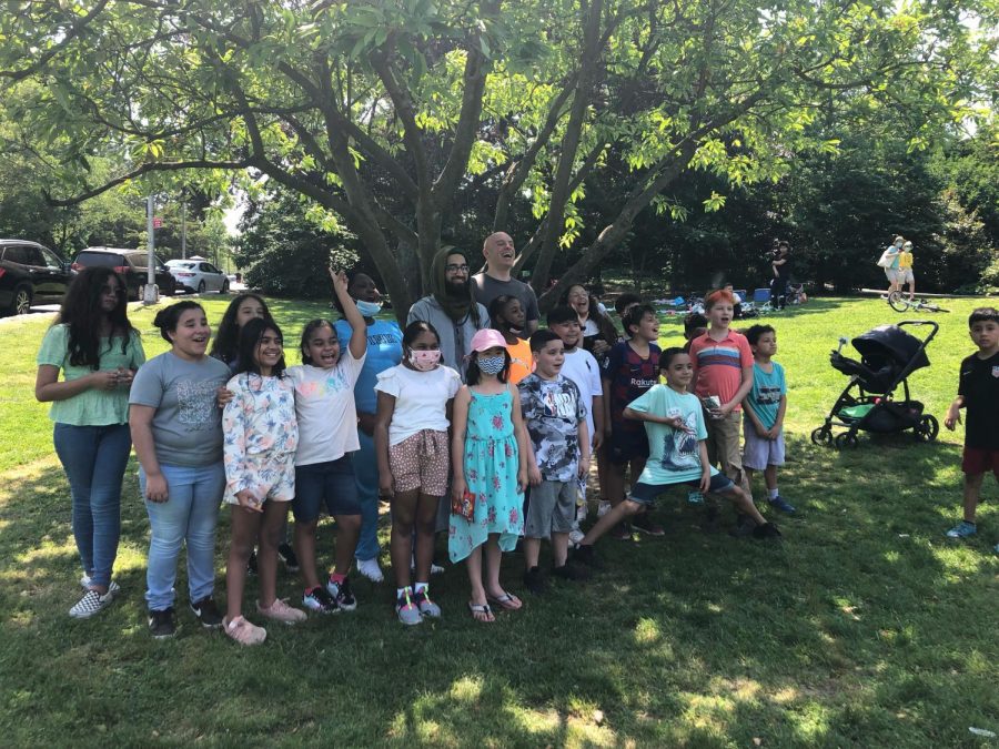 A gathering of students in a backyard, with their teacher, Mobeen Ahmed, at the center.