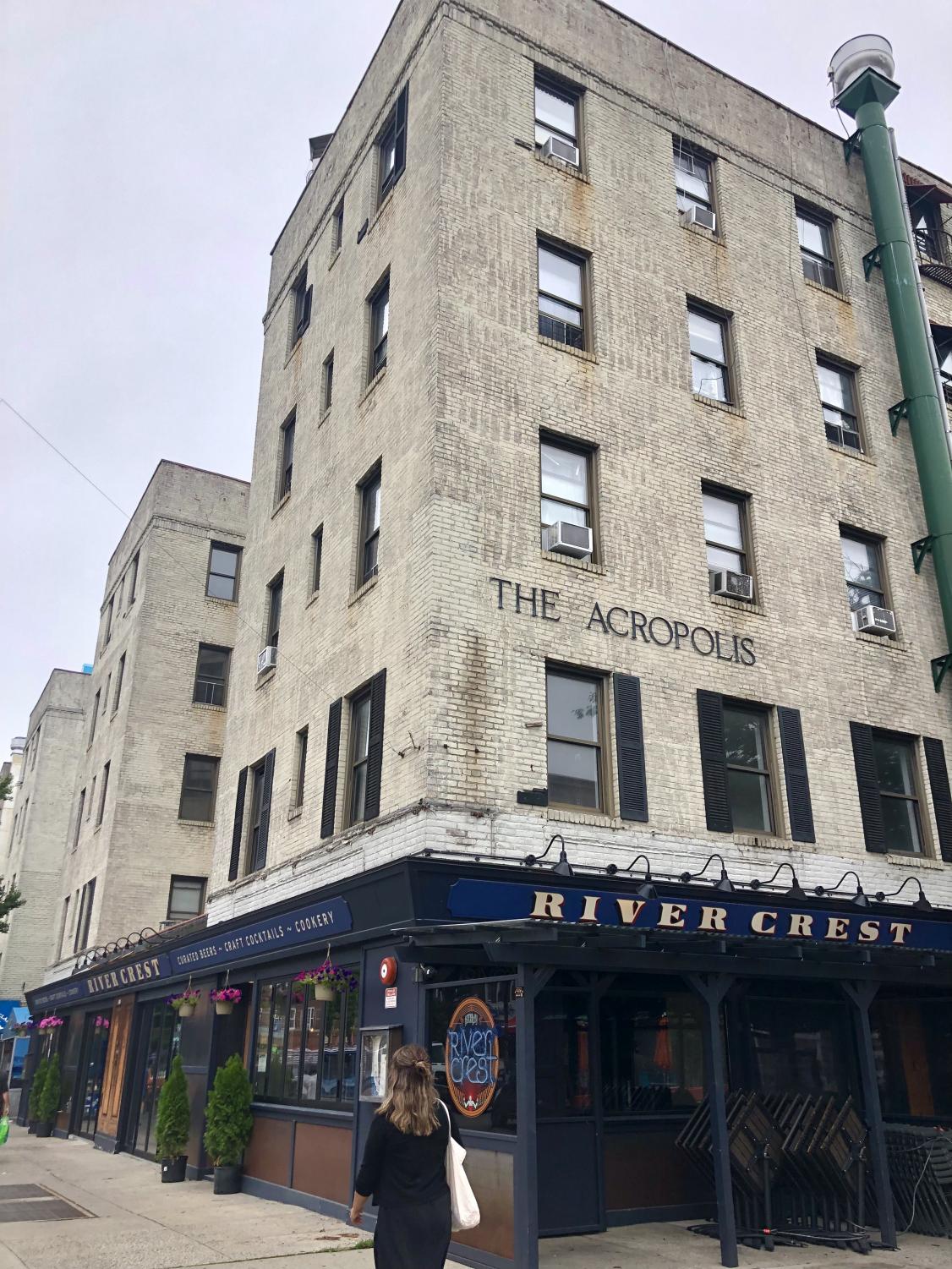 The Acropolis condominium is tan and has its name across the side of the building