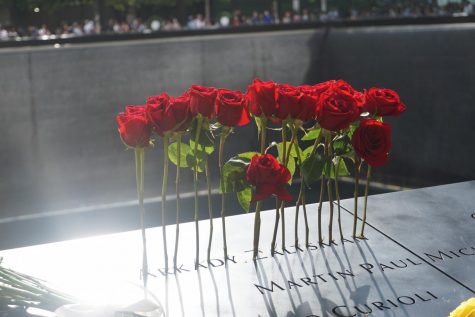 13 roses in a name at a 9/11 memorial pool