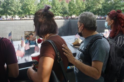 two people standing in front of a 9/11 memorial pool