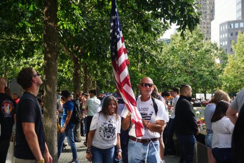 a man holding an American flag in the middle of a crowd