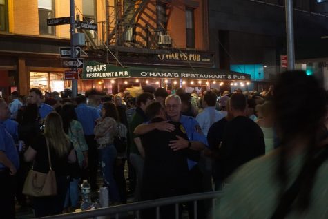 a crowd with two police officers hugging in the middle