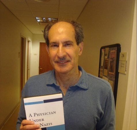 David Glenwick holding a book that he wrote