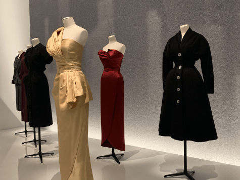a gold, red, and black dress at a Dior showcase at the Brooklyn Museum
