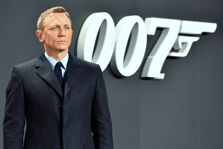 Daniel Craig standing in front of a 007 sign with a gun pointed out of the 7, a symbol of Craigs run as James Bond