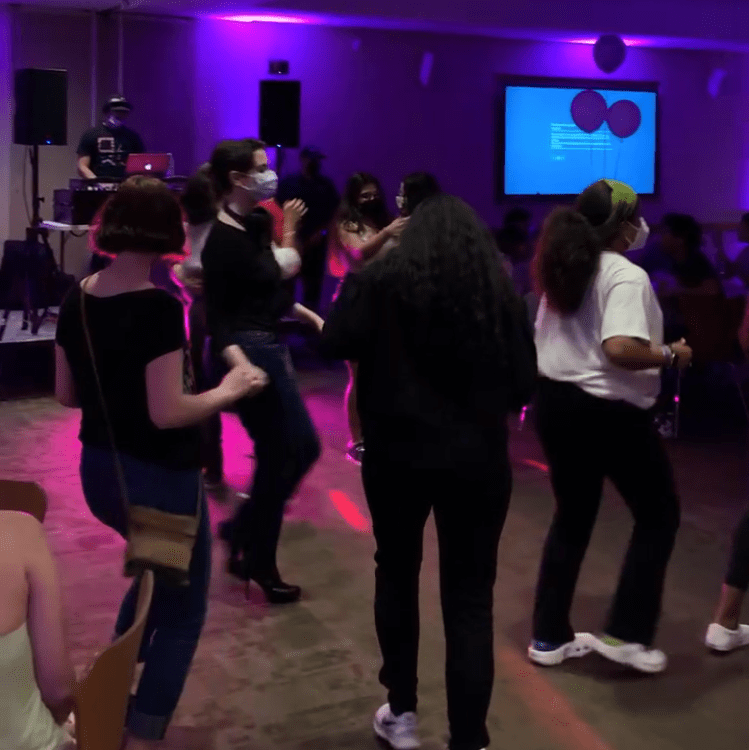 at mucho gusto hosted by SOL at fordham, students dancing with pink and purple lighting