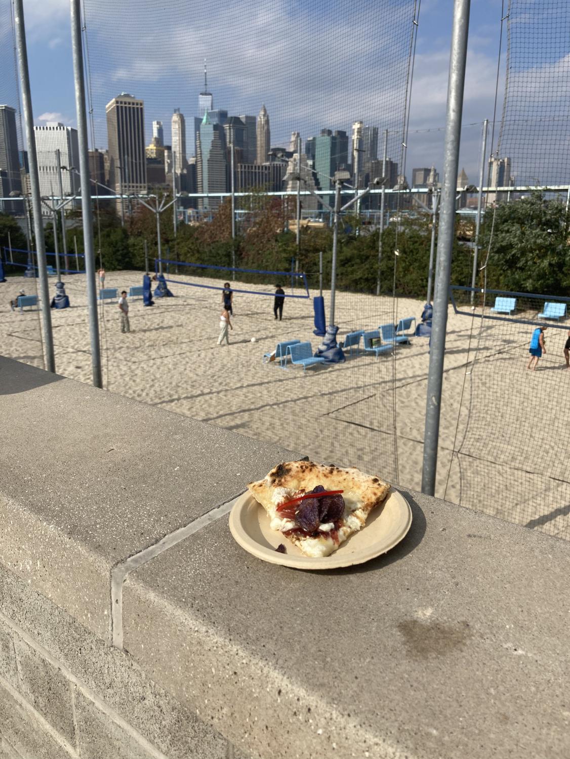 image of pizza on concrete wall looking over to the city skyline