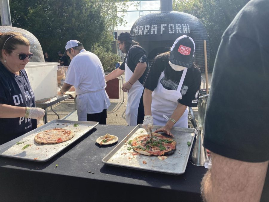 at the 2021 nycwff, people cut up pizza in front of authentic ovens