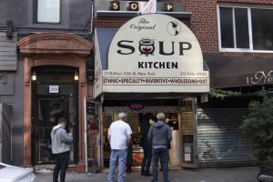 soup kitchen seinfeld on 55th street with people standing in front of it
