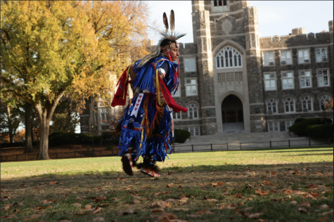 a man dressed in traditional American indigenous clothing in front of a building