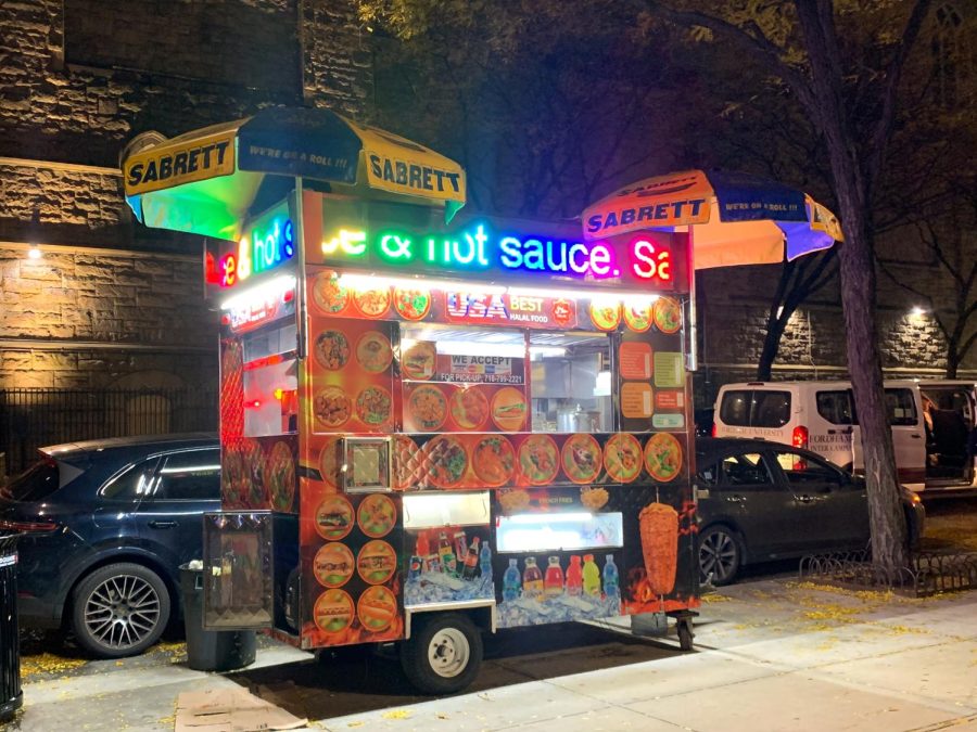 a halal cart on a street corner with rainbow words at the top