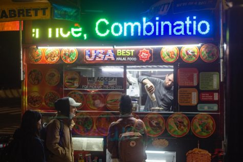 a halal cart with rainbow colored words listed as menu items in lights