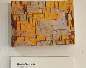a placecard with toe tags and a label that says Hostile Terrain
