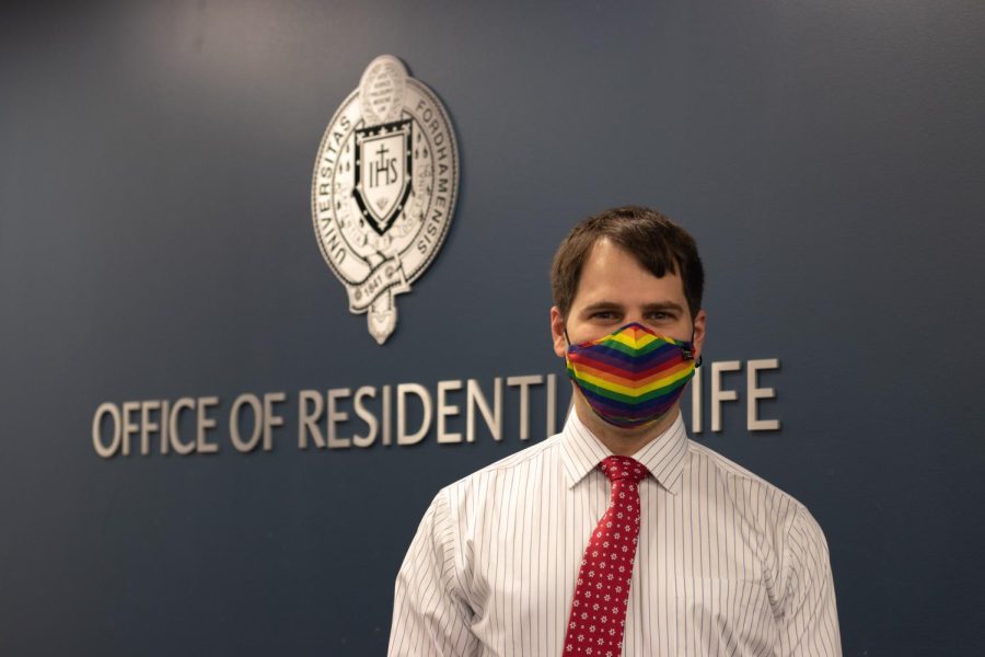 greg jones, new reslife director stands in front of office of residential life wearing a mask