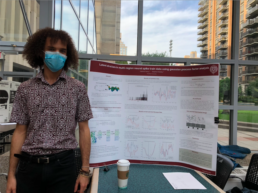 gabe yancy stands at natural science symposium in front of his poster