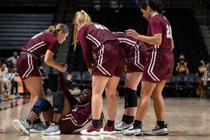 womens basketball plays Rhode Island helps asiah dingle up from the ground
