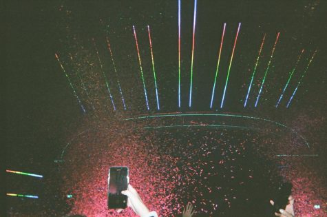 hand with cell phone with lights and confetti