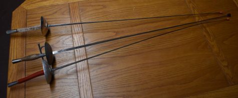 three rapiers on a wooden table