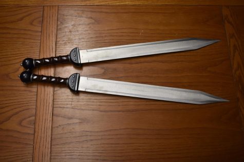 two short swords on a wooden table