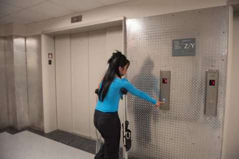 for an article on accessibility, a girl tries to use the elevator while using crutches