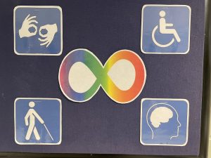disability studies program sign with infinity and deaf, blind, wheelchair and brain logos on a sign