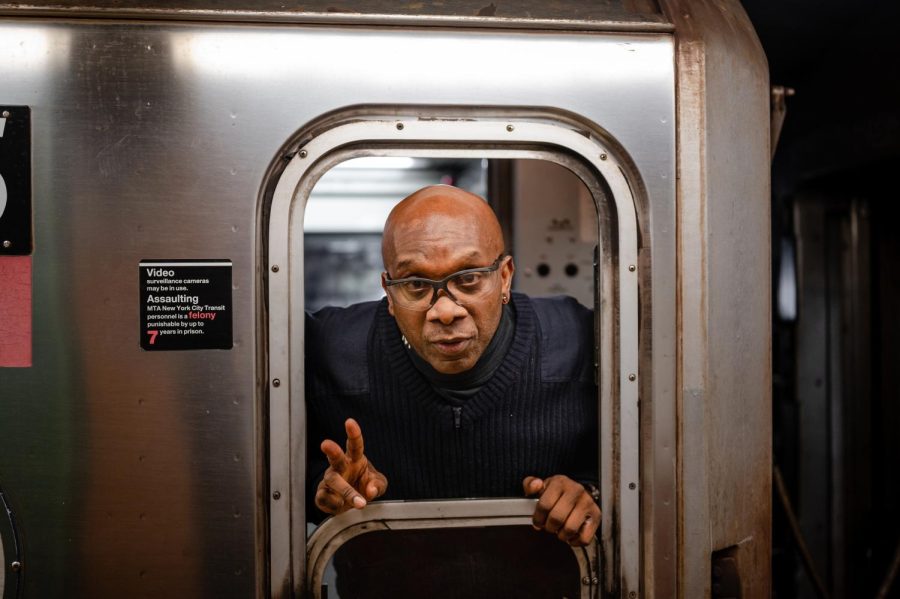 A train operator motions a peace sign to the camera after dropping the window and says Have a good day now as his train leaves. 