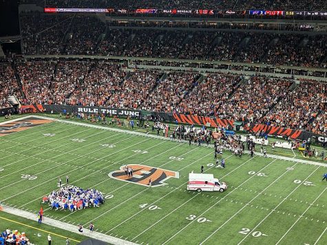 Damar Hamlin is removed from the field by an ambulance as Bills and Bengals players kneel.