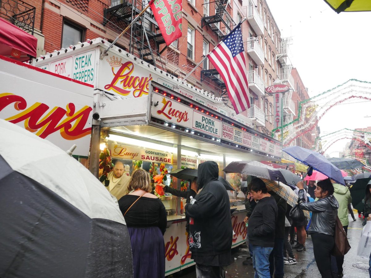 Visitors line San Gennaro’s festival streets and brave the stormy weather to get a taste of fresh Italian cuisine.