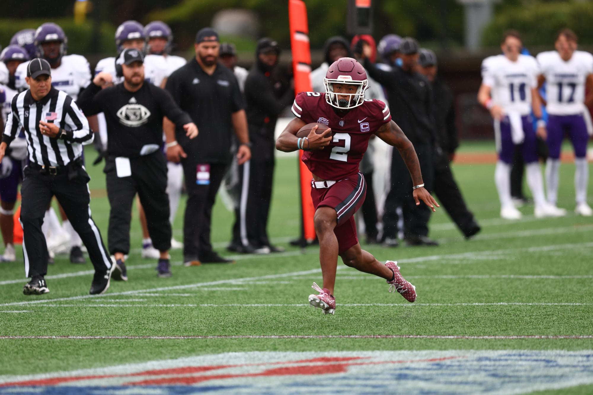 MJ Wright, GGSB ’24, sprints along the sideline while Stonehill players and coaches look on. He finished with three receptions for 58 yards and a touchdown.