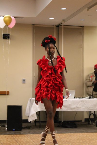 One of the student-models struts the runway in a red-ruffled dress.