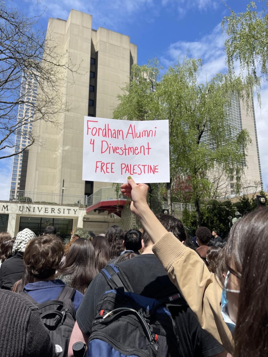 A student holds a sign calling for Fordham to disclose its investment portfolio and divest from arms manufacturers at a pro-Palestinian rally on Thursday, April 25.