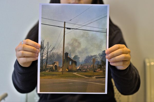 Dalia Lundquist, a freshman at FGSB, holds up a photo of a house from the neighborhood right next to her school. 