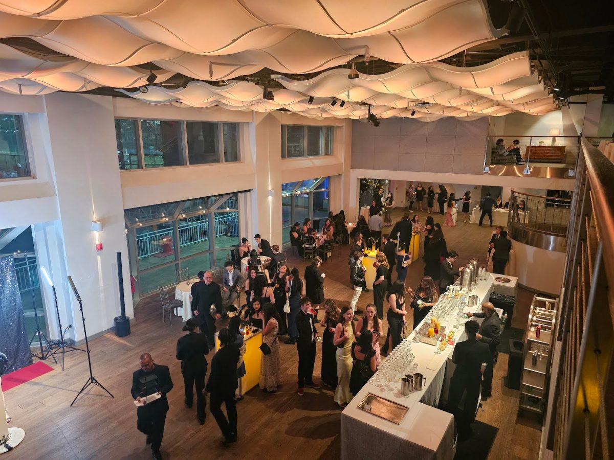 Attendees congregated at the bar before the start of the Winter Ball. Many attendees enjoyed hors d'oeuvres, while others sipped on mocktails and ordered drinks, enjoying the views from Chelsea Piers.